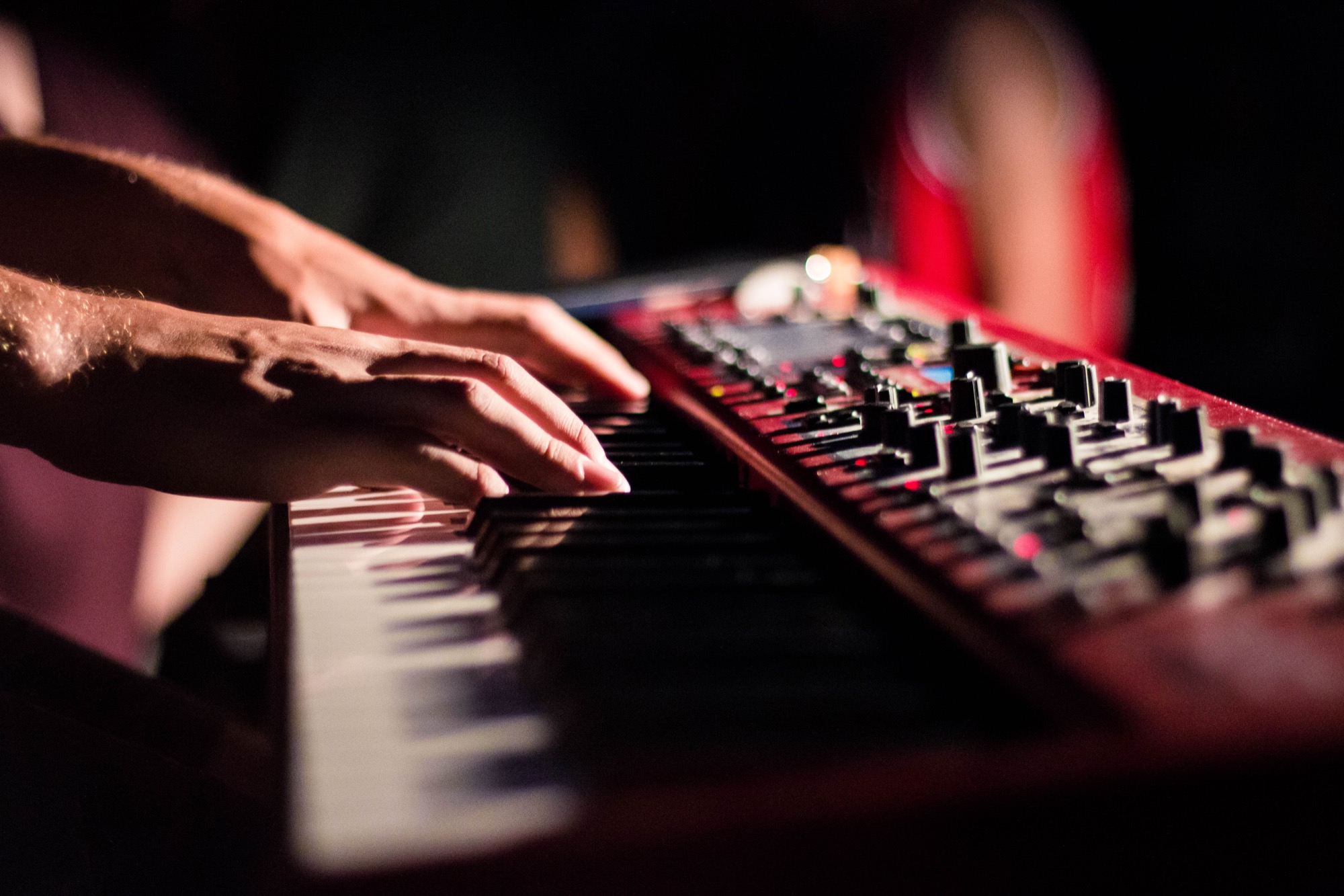 Pianist am Keyboard, unterstreicht die Bedeutung der Versicherung von Musikinstrumenten für Künstler, angeboten durch Künstler für Künstler.