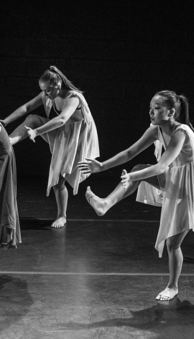 Tänzer auf der Bühne, um die Wichtigkeit von Betriebshaftpflichtversicherung für Künstler zu symbolisieren.